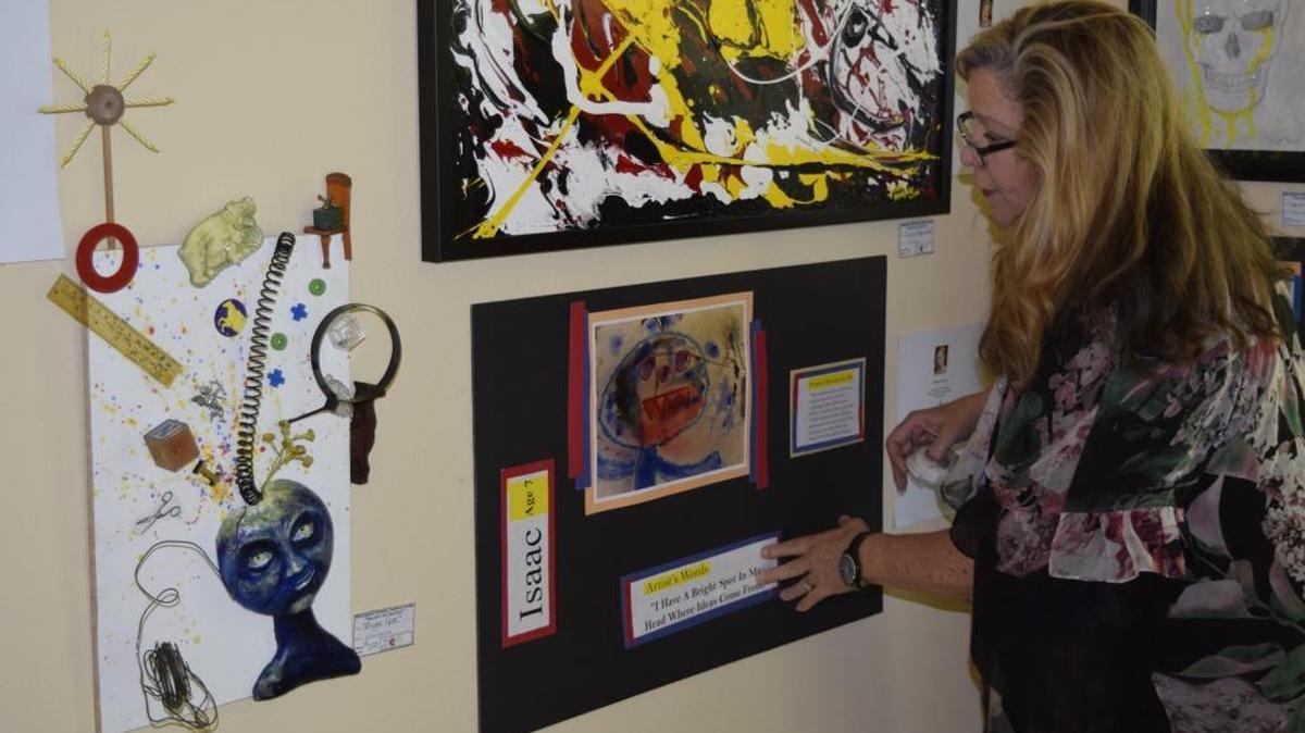Art hangs in Cressey Manor on 17th Street in Modesto for the Art of Justice fundraiser to be held Wednesday, March 23. The show is of children’s artwork alongside interpretations by adult artists. Each child’s piece also includes the “Artist’s Words,” brief statements they made as they worked. Here, Cindy Schneider, director of community partnerships at the Stanislaus Family Justice Center, affixes a young artist’s words to his artwork display. “I have a bright spot in my head where ideas come from.”