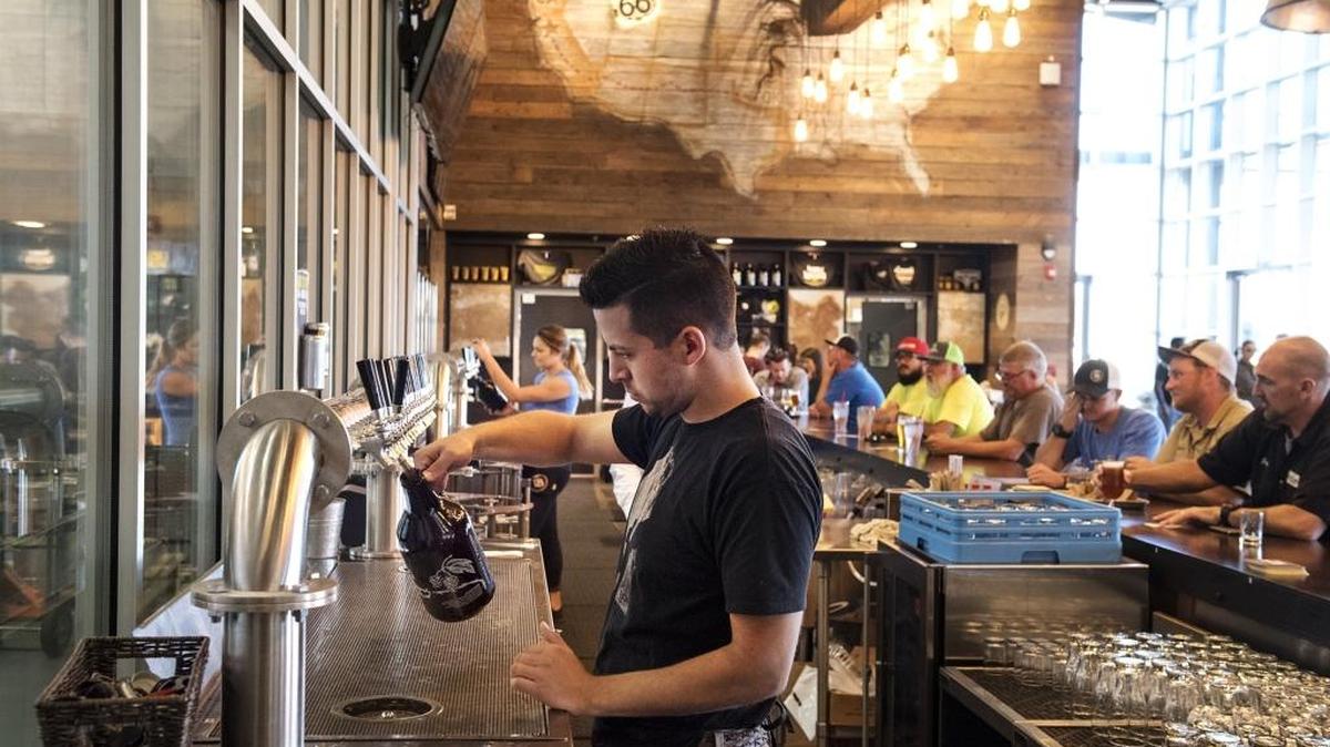 Bartender Raul Rivera fills a growler at Dust Bowl Brewery in Turlock in August. The industries with the biggest job growth in Stanislaus County over the past year included leisure and hospitality.