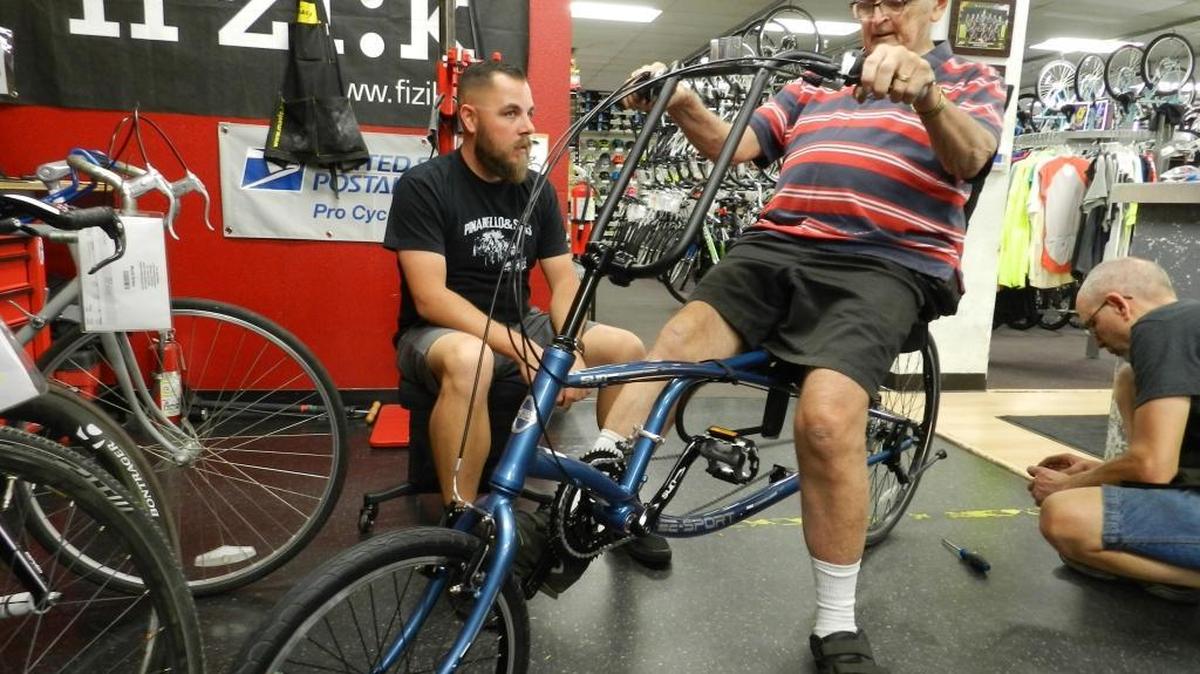 
Brian Zahra, co-owner of Fun Sport Bikes in McHenry Village, helps adjust a new recumbent bicycle for David Barnett at the shop on Thursday.
