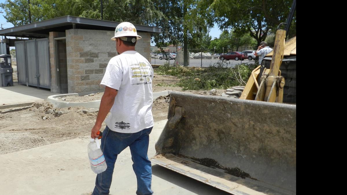 
Laurenio Andrade with GHI Hedgecock paving of Modesto takes a water break while working at the Safeway shopping center on McHenry Avenue on Tuesday.
