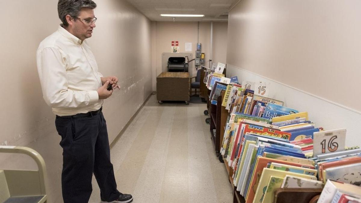 Library manager Michael Leamy points out the book intake area is part of the basement space where the floor will be replaced at the Modesto library in Modesto, Calif., on Wednesday, October 19, 2016. The library will close one day for asbestos abatement.