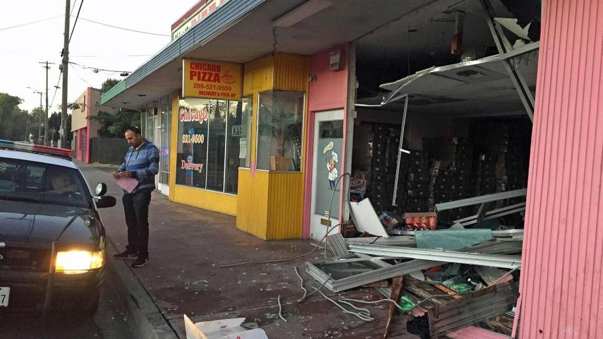 Chicago Pizza owner Charanjit Chahal and police check out the damage in October after a Modesto officer crashed his patrol car into the La Loma Avenue eatery. The city paid $9,423.71 for the damage.