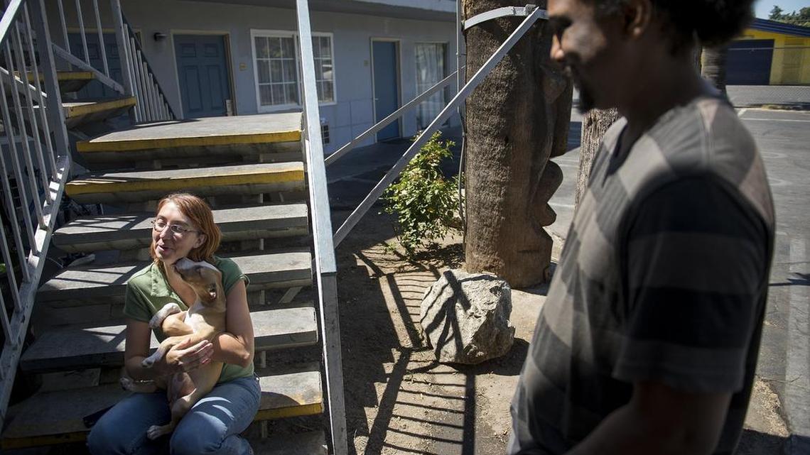 
Amy Smith holds Luna at the Tiki Lodge on McHenry Avenue in Modesto on Monday. She and her husband, Taven Jamal Smith, have been staying at the motel using county vouchers while they wait for permanent housing. 
