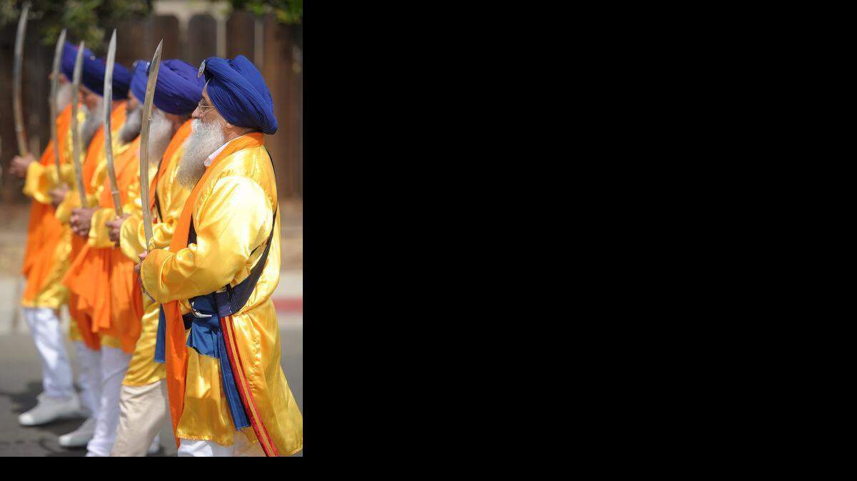 
Turlock’s Tarsen Singh holds a ceremonial sword with other Sikhs the 2014 parade celebrating the holiday of Holla Mohalla.
