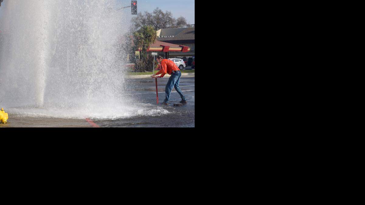 
Jaden Tunnell, a city of Modesto Water Department worker, turns off the water to the gushing hydrant that was sheared off by a semi truck Monday at Five Points in downtown Modesto.
