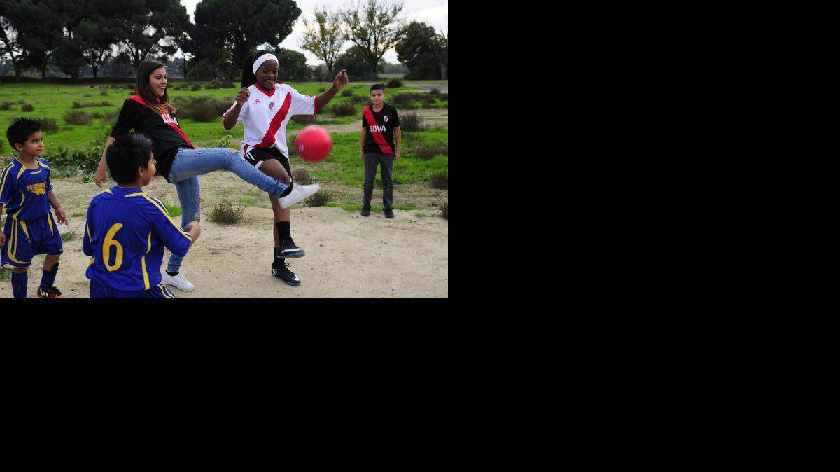 
Viviana Albor, 14, left, and Jamani Prince, 13, play around with a soccer ball Friday on a piece of land on John Street in Modesto that might soon become six soccer fields. Stanislaus Youth Soccer League got the go-ahead to build fields on Tuolumne River Regional Park land.
