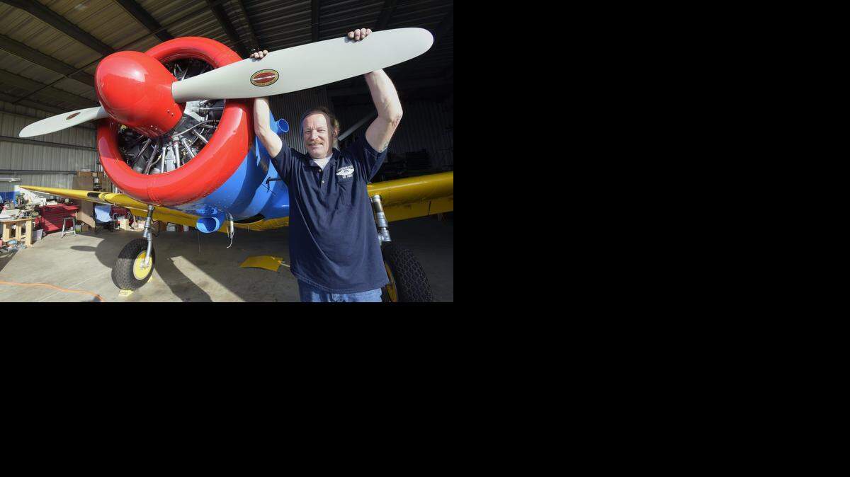 
Jason Reid holds on to the 9-foot-long propeller on his 1942 Vultee BT-13A trainer aircraft Sunday at Modesto Airport. Reid has been working on the plane since 2010 and is almost finished.
