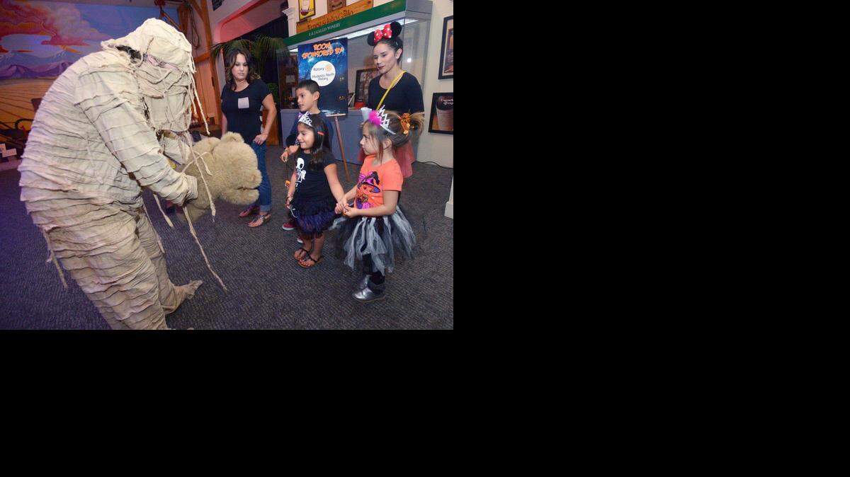 
The mummy shows off his teddy bear to attendees Michelle Para and her son Arthur, 8, daughter Amerie, 5, friend Illiana Garrett, 5, and tour guide Melina Barragan dressed as Minnie Mouse at the Haunted McHenry Museum that benefits the Boys & Girls Clubs of Stanislaus County.
