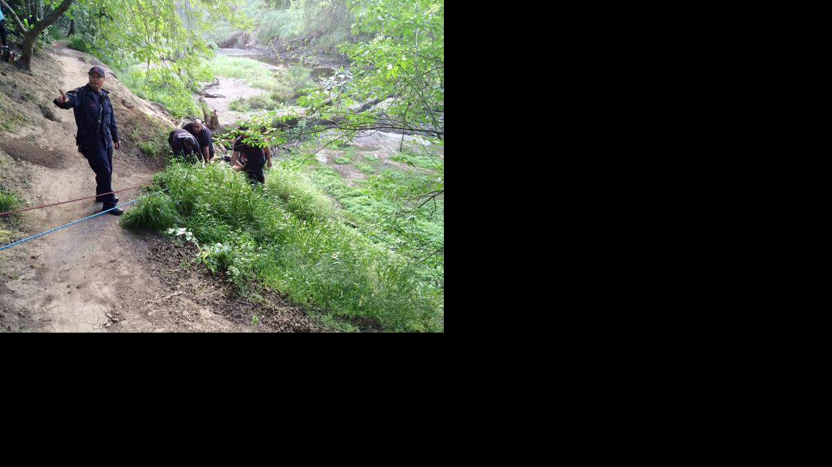 
Firefighters rescue a man who fell down a 25-foot embankment after hitting a low tree limb while bicycling in Kewin Park on Monday evening.
