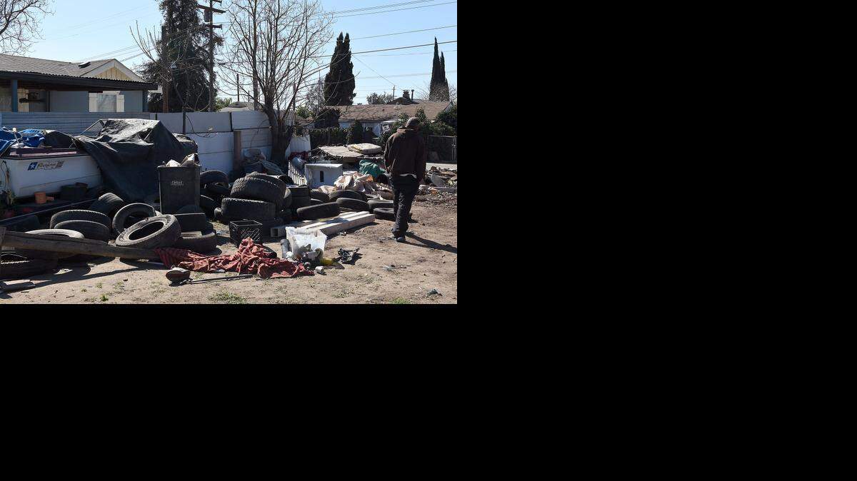 
A resident of Elm Street in Salida walks through an area filled with junk and trash on Wednesday morning.
