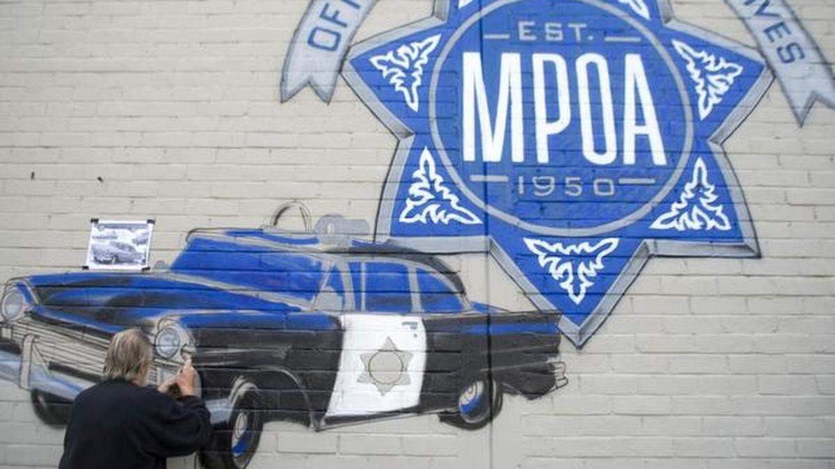
Artist Tom Nye works in 2014 on a mural on J Street in Modesto commissioned by the Modesto Police Officers Association.