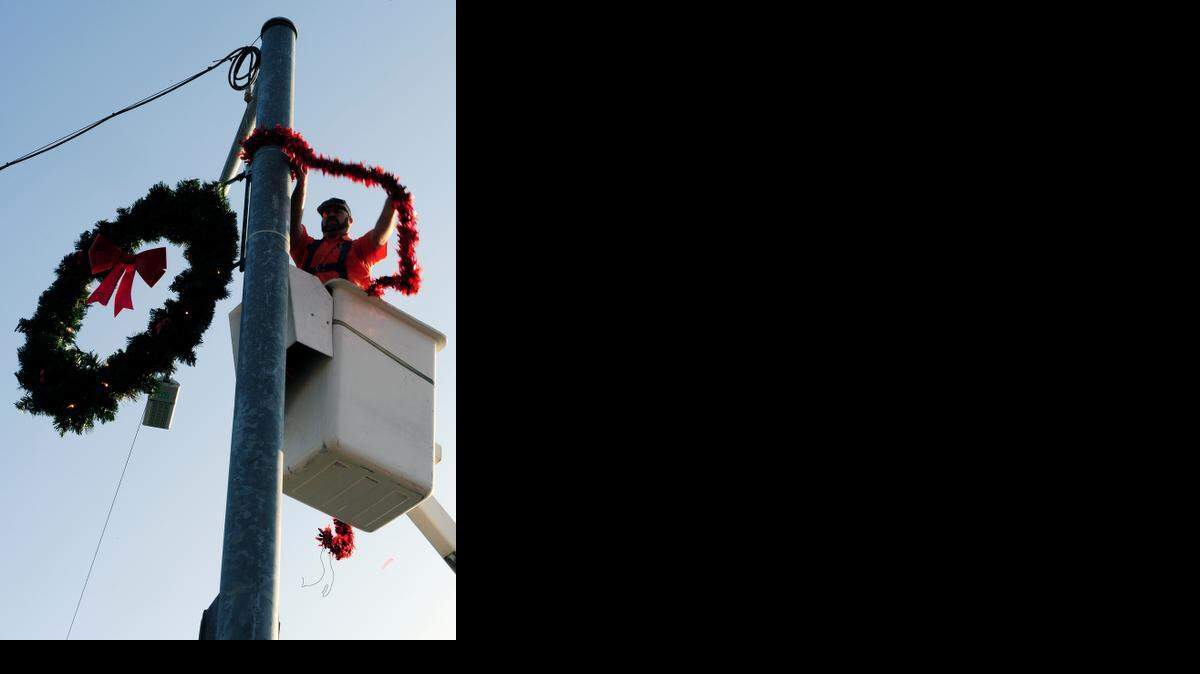 
Hank Unruh, a maintenance operator with the city of Ceres, hangs garland and a wreath Tuesday morning (11-25-14) at Mitchell Road and Whitmore Avenue in Ceres, CA. City employees hung 10 wreaths Tuesday, five at Whitmore Avenue and Moffett Road and five at this intersection.
