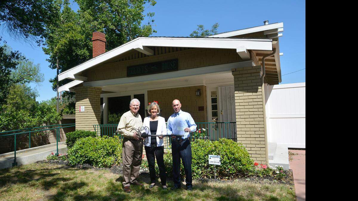 
Cricket’s House founder Jean Walker Lowell and President Todd Venturini, right, hand over the ceremonial key to the home on Downey Avenue to Stanislaus Family Justice Center Director Tom Ciccarelli on Thursday. The Christopher P. Walker Foundation donated Cricket’s House to the center.
