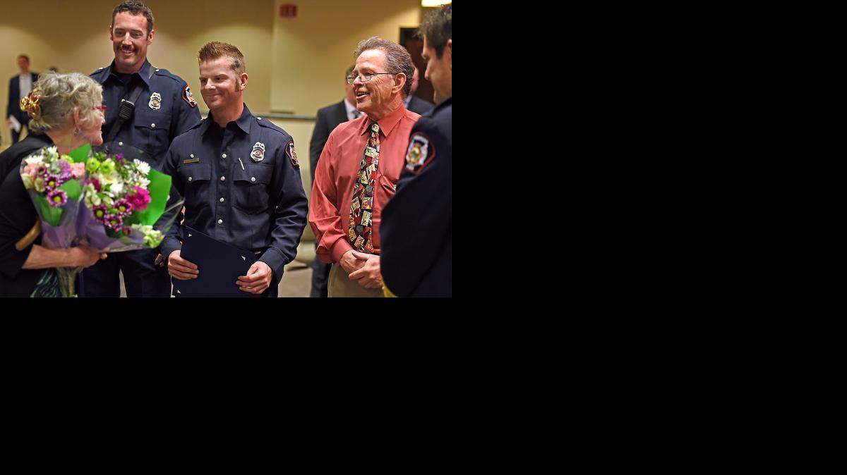 
Modesto firefighters Jesse Miguel, center, and Jason Wyatt meet Deloris Dobbins, a woman they saved from an apartment complex fire in mid-February. The two firefighters were honored Tuesday evening at the Modesto City Council meeting.
