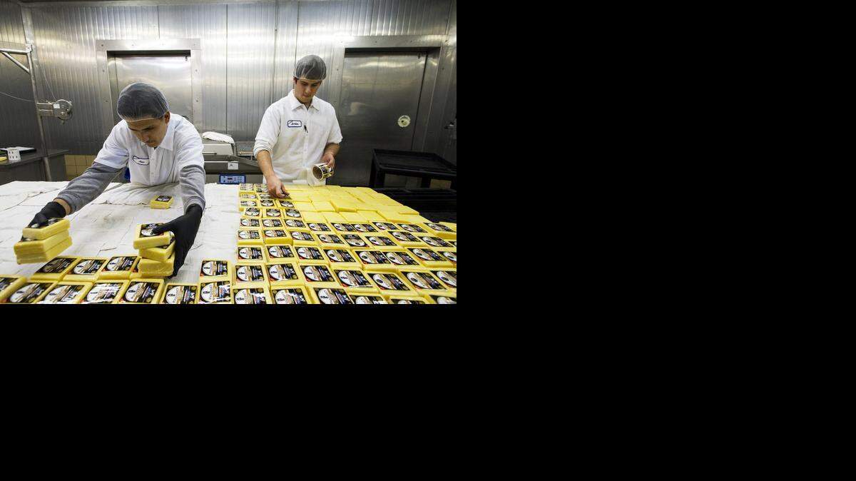 
Jose Alderete, left, and Jordan LaCoste process cheese at Fiscalini Cheese Co. in Modesto on Tuesday. 
