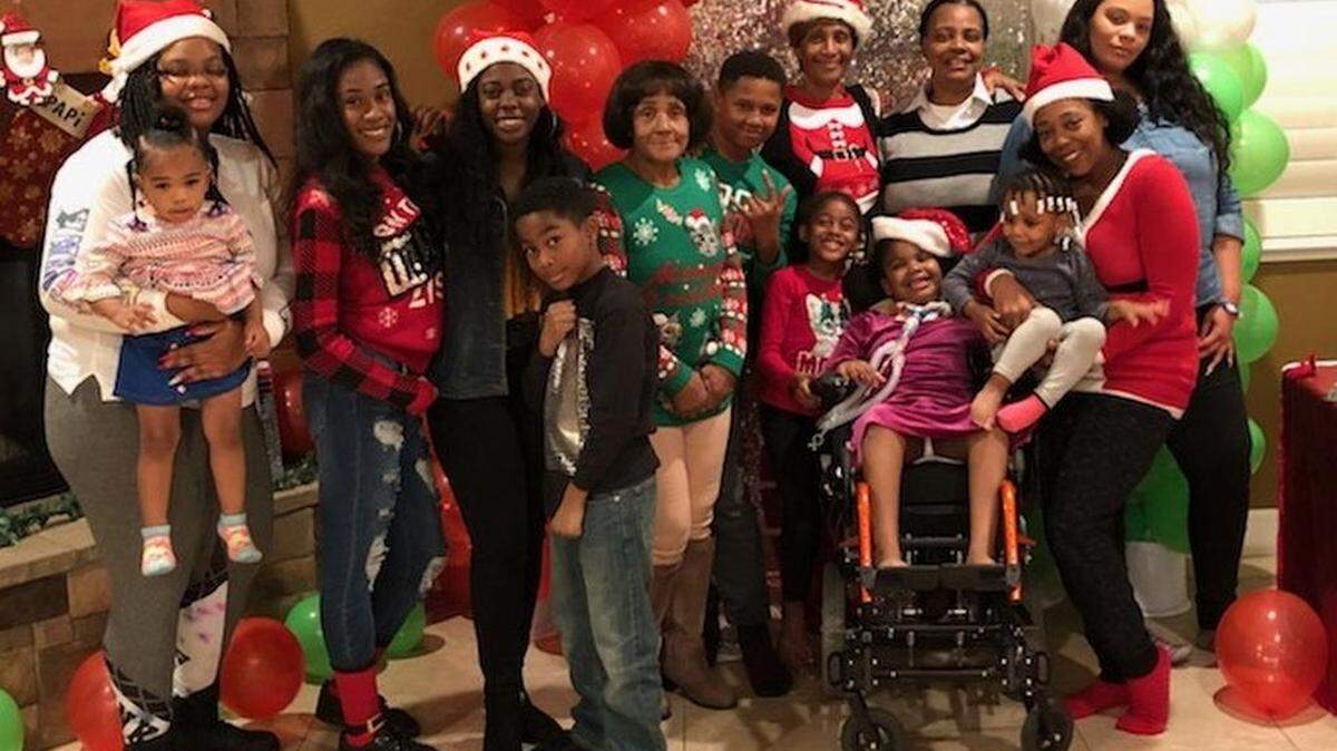 Her family threw a surprise Christmas party Sunday for Genevieve "GG" Grayson, in wheelchair toward right. At the far left is her mother, Shawnta Lynnell, holding GG's little sister, Gia.