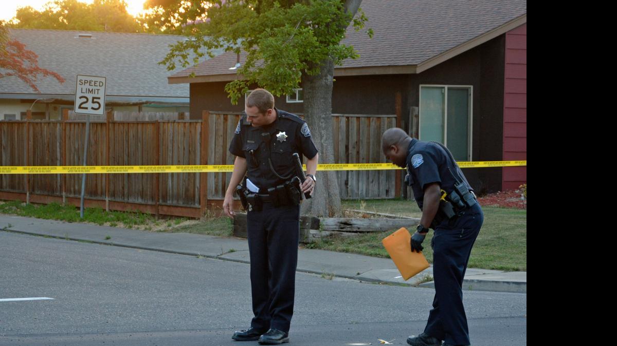 
Modesto Police Department officers look over the scene of an apparent drive-by shooting that left two people with injuries on Friday, May 29, 2015. The shooting apparently took place near the intersection of Keller Street and Falmouth Way in northeast Modesto, Calif. 
