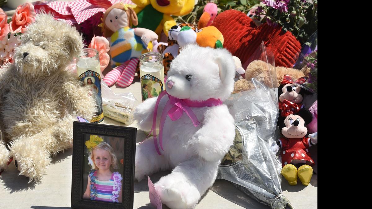 
A picture of 6-year-old homicide victim Elizabeth Ripley sits amid a makeshift memorial Monday at a home on Nob Hill Court in Modesto, where the bodies of two adults and three children were found Saturday. 
