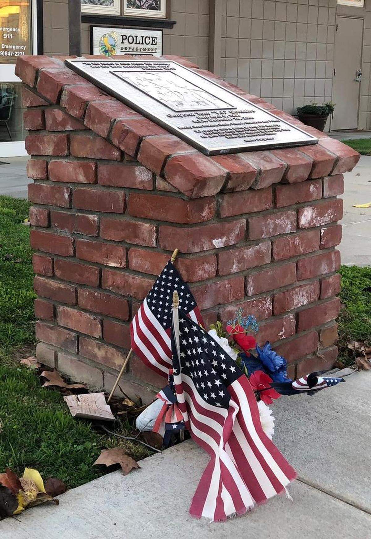 At the Newman Police Department on Main Street, a vase with flags and flowers sits next to a memorial on Wednesday morning, Dec. 26, 2018. The flags also flew at half staff in honor of Cpl. Ronil Singh, who was fatally shot early that morning.