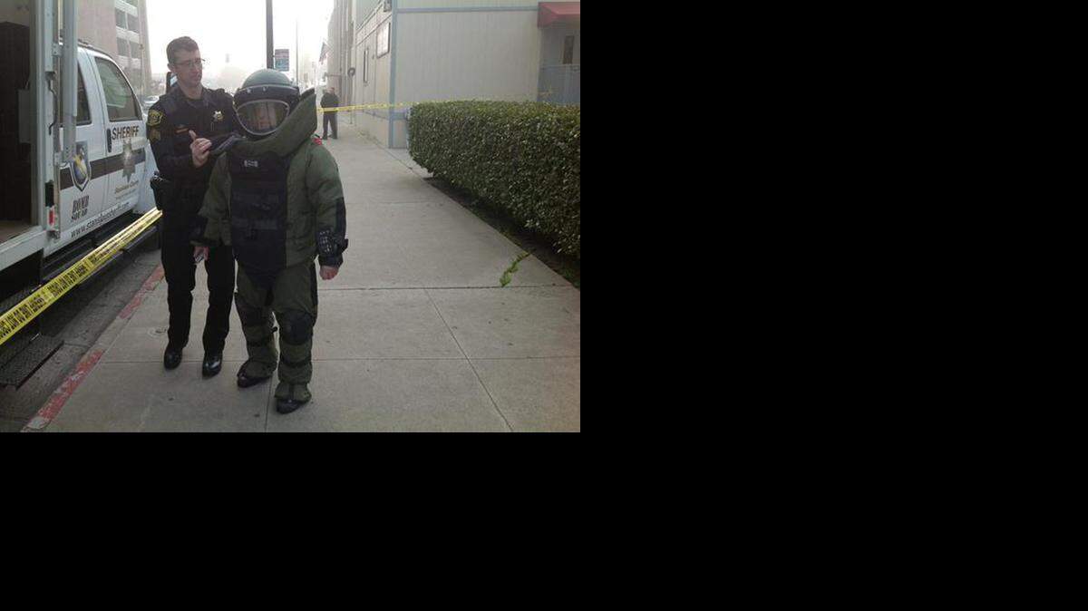 
Sgt. Frank Fenn puts on a protective suit to remove suspicious suitcase found near an employee entrance at the Stanislaus Superior Courthouse Friday morning Jan. 30, 2015.
