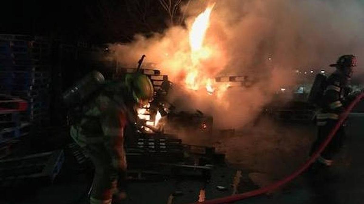 Firefighters work to extinguish a pallet fire intentionally set behind the Sonora Walmart store early Friday.