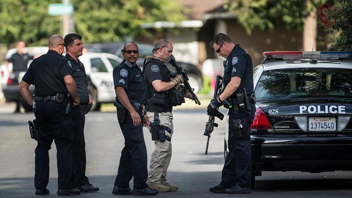 
Modesto police officers prepare to search for a gunman on Pelton Avenue in Modesto on Wednesday.
