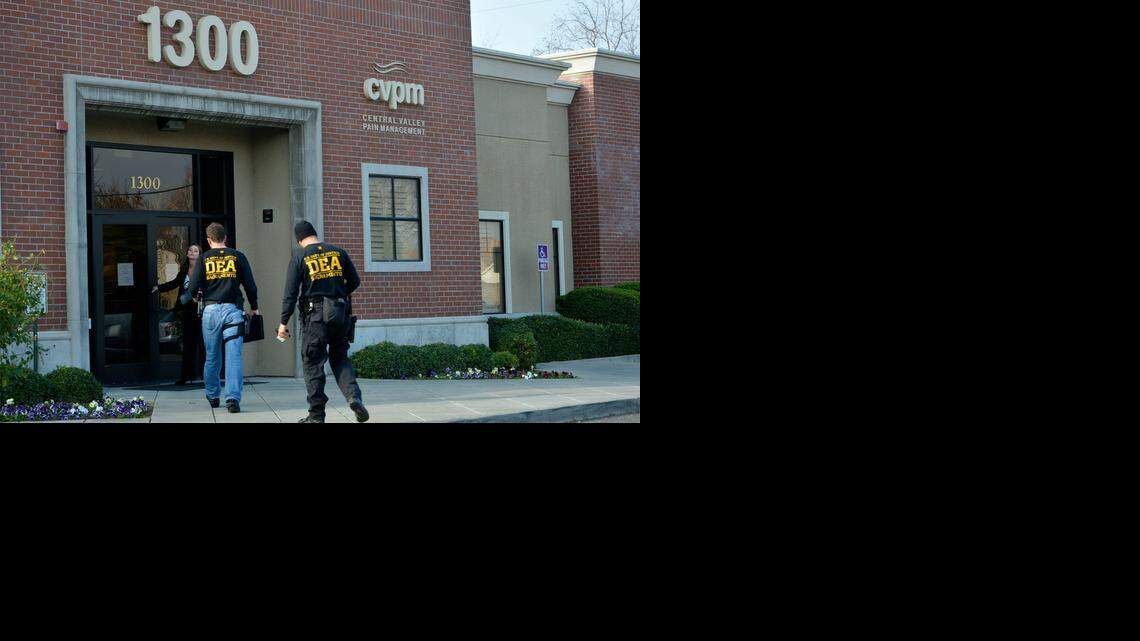 
Attorney Tracy Toledo lets drug officers officers into Central Valley Pain Management on Mable Avenue in Modesto on Tuesday. Modesto Police Department Narcotic Enforcement Team officers and U.S. DEA agents searched records at the business after the office manager there was arrested in connection with a prescription drug ring.
