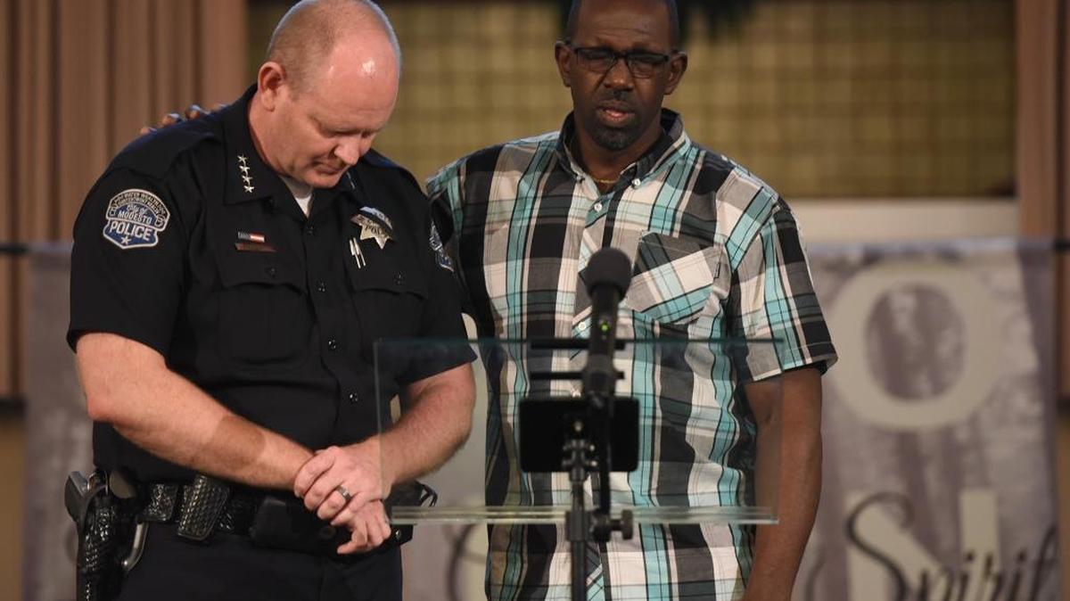 Elder Gary Patton gives a prayer for law enforcement and its leadership with Modesto police Chief Galen Carroll at a vigil Friday evening, July 8, 2016, at Davis Park Church of Christ in Modesto, Calif.