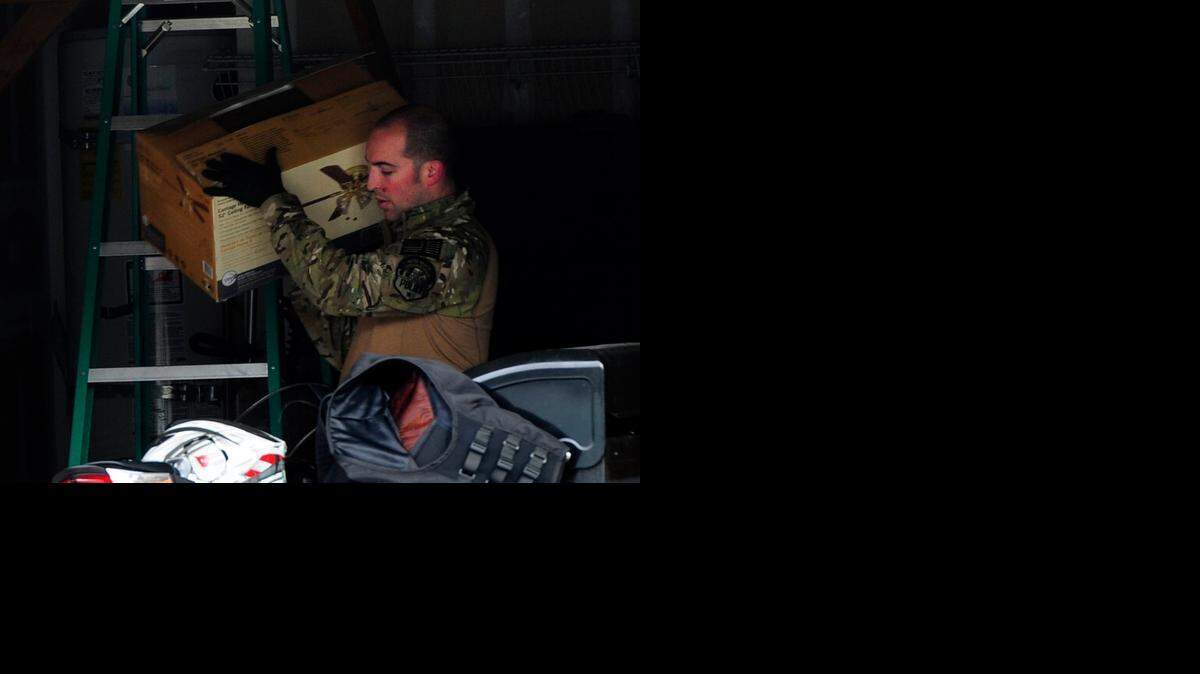 
An officer with the Modesto Police SWAT team looks over items in a garage Wednesday morning  on Yerington Court in Modesto. Police locked down Enochs High School while serving a warrant in the neighborhood that is roughly one block  south of the school.
