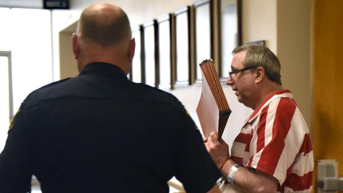 A Stanislaus County law enforcement official stands guard as Mark Edward Mesiti  leaves court after being sentenced in February 2018.