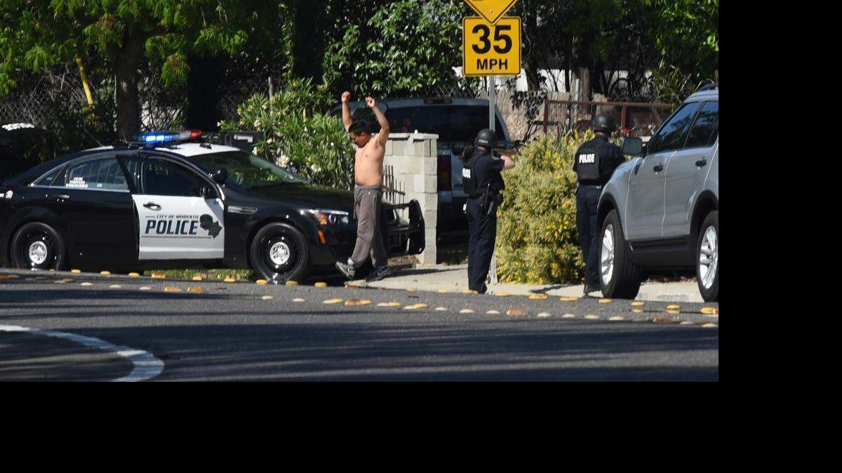 
A man is detained by Modesto police in the 3500 block of Scenic Drive on Thursday morning. One person was shot in the leg and two men were detained. 
