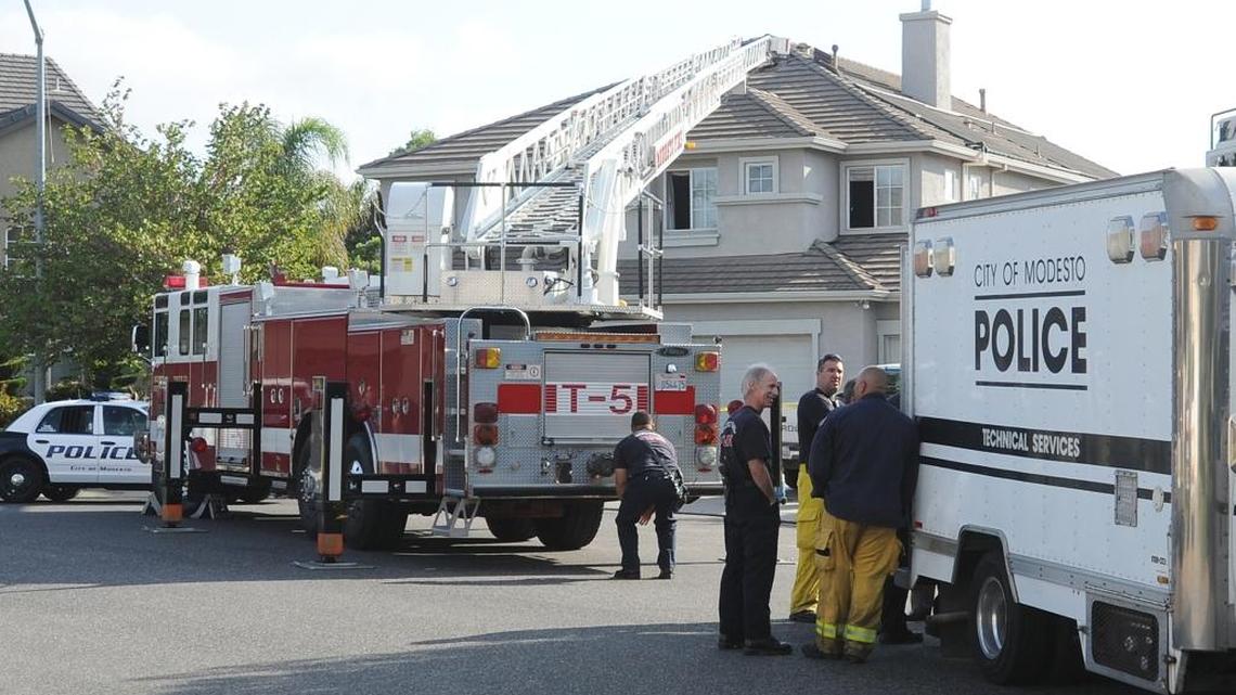 Firefighters and police gather on Divan Court in north Modesto, where Scott and Janet Pettit were found dead inside their burning home early Thursday Aug. 8, 2013.
