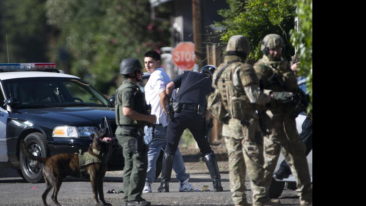 
A suspect is arrested behind a home on High Street in Modesto on Monday.

