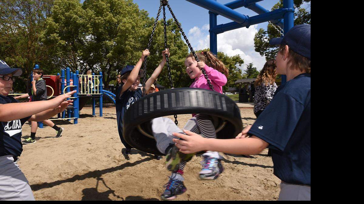 
Morgan Western, 6, and Garrett Reed, 8, enjoy the new tire swing at Lakewood Park in east Modesto on Saturday morning. The park’s playground was recently repaired and updated in a partnership with the city of Modesto and area residents.
