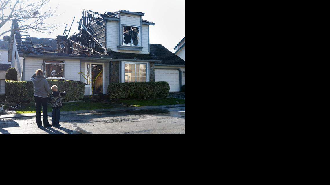 
Jane Knight and her grandson Christopher, age 6, look at the devastation from the fire that happened earlier on Jan. 1, 2015 to their friends and neighbor in the 2800 block of Sand Stone St.
