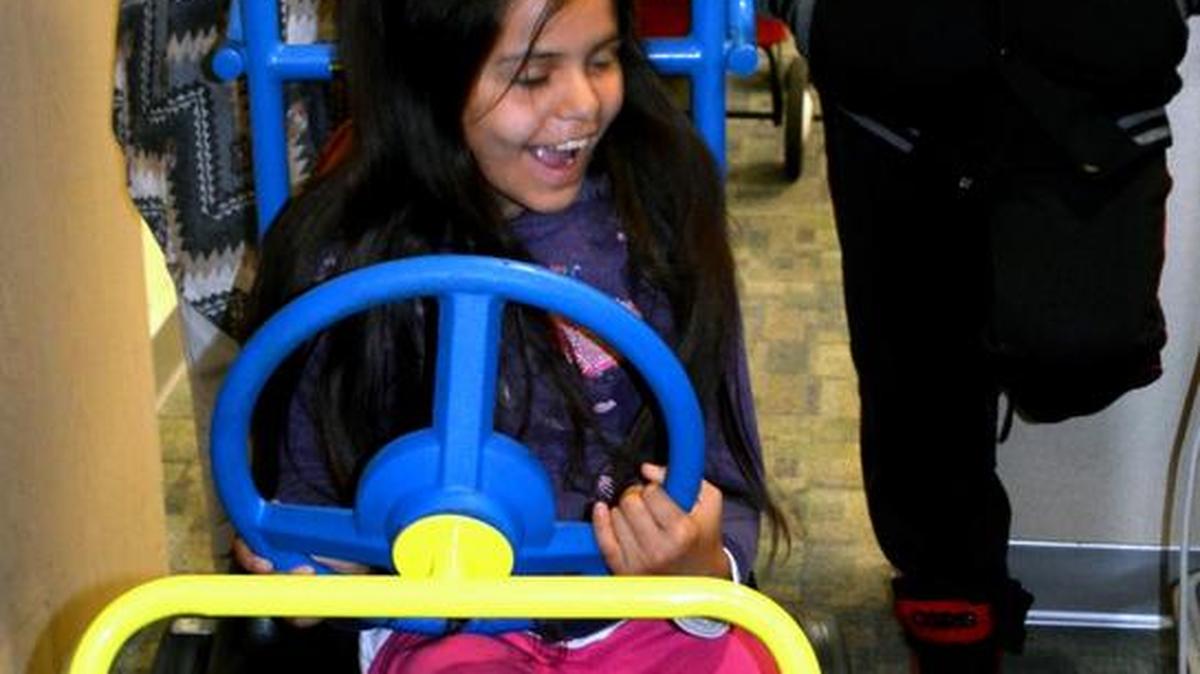 Sixth-grader Gailea Perez takes a turn in the pediatrics ward cart pushed by nurse Kerry Roach at Memorial Medical Center in Modesto. The cart is used to help patients get out and about without having to push an IV pole alongside.