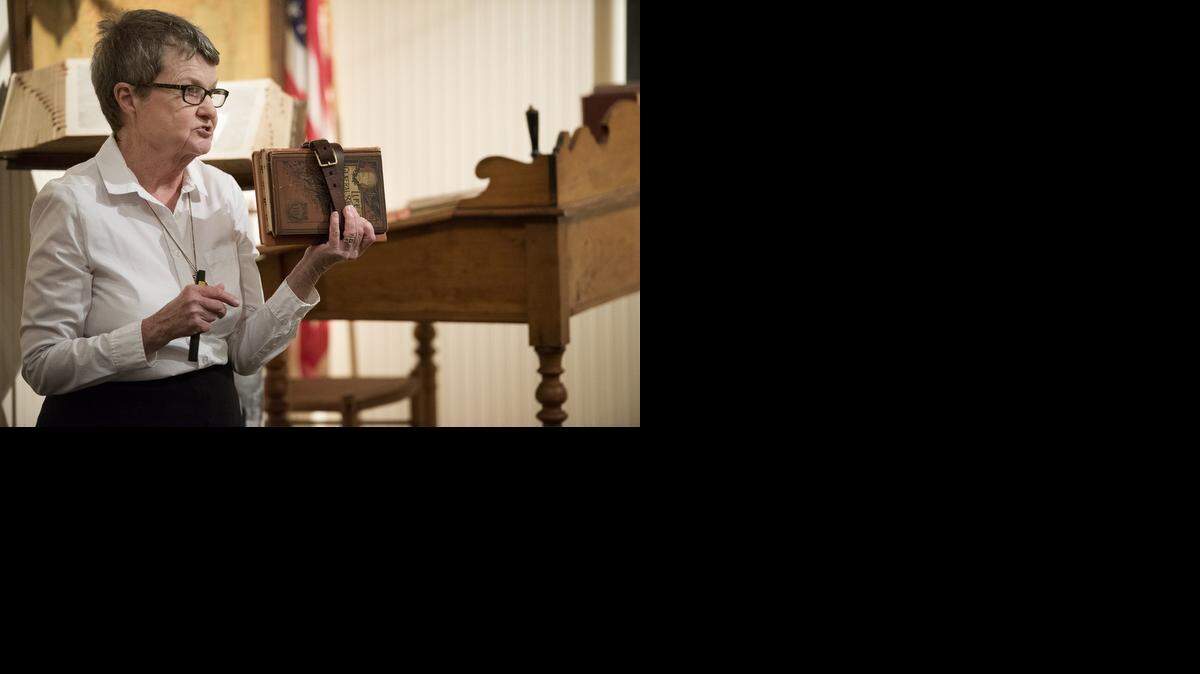 
During Second Saturday at McHenry Museum, docent Karen Tiffin describes how schoolchildren brought their own books to school banded together with a leather strap – the 1900s version of a backpack.
