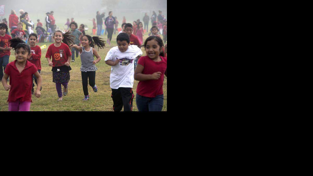 
Chrysler Elementary School students Aaliyah Hernandez, left center, and Vivyana Duarte, center, both 5, run with others Friday morning during the school jog-a-thon in Modesto.
