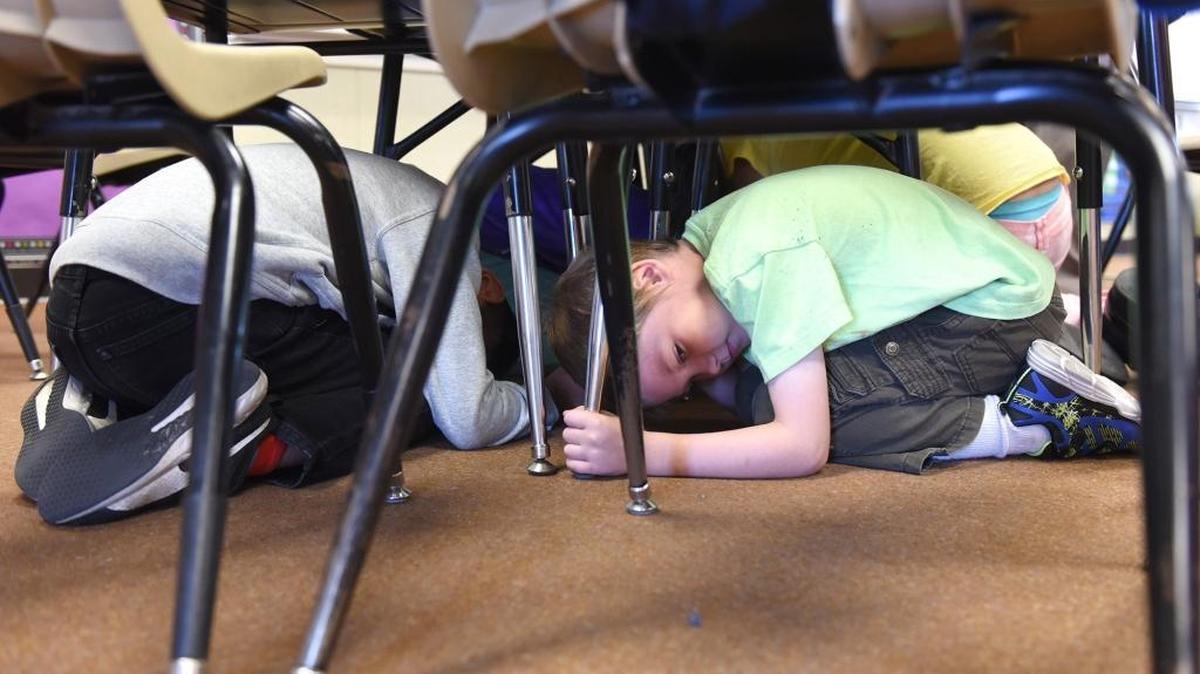 Second-grader Douglas Eller gets under his desk with his classmates Thursday morning, Oct. 20, 2016, at Kirschen Elementary School in Modesto, Calif. The kids participated in the Great California Shake Out, an annual drill at schools.