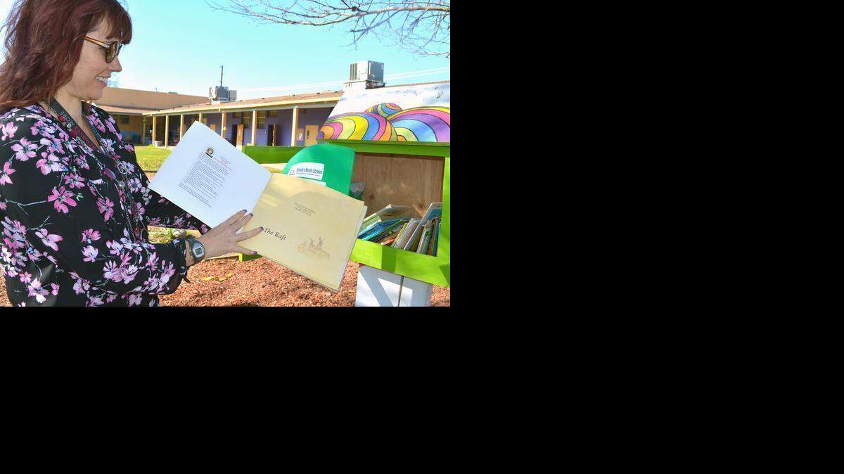 
Aspire Summit Charter Academy Principal Jamey Olney pulls a book to read from one of two tiny library boxes mounted in the school garden in south Modesto on Thursday.
