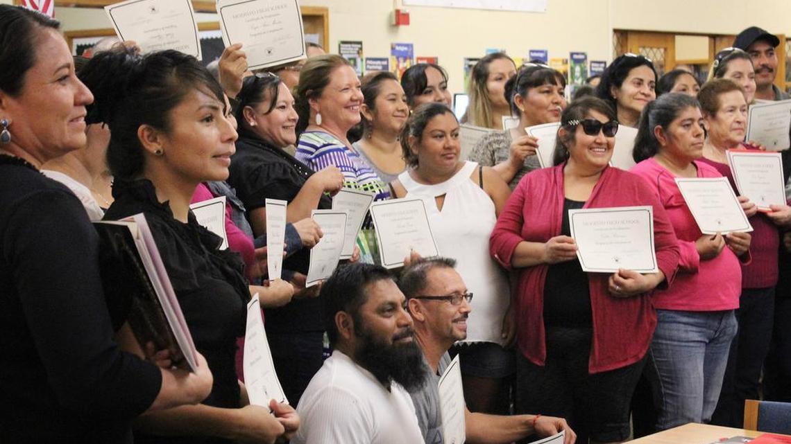 The 45 Modesto High parents who finished the four-week basic computer course pose with administrators after receiving their certificates on Thursday, Oct. 6, 2016, in the school’s library in Modesto, Calif.