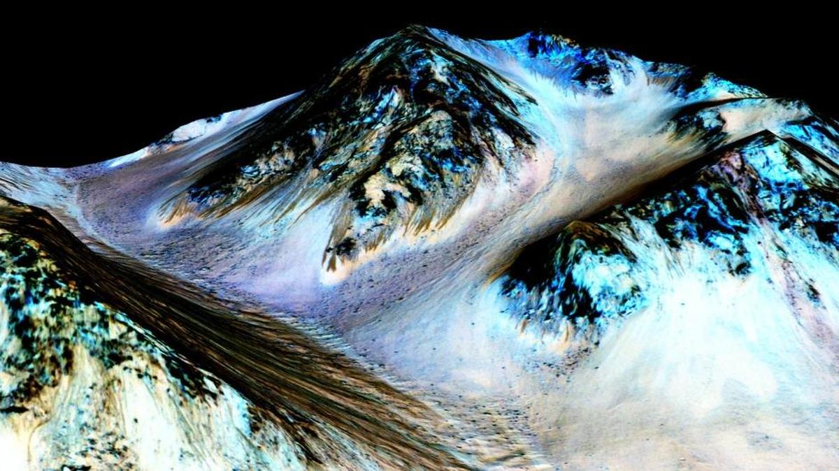 
A photo taken by an instrument aboard the Mars Reconnaissance Orbiter shows dark, narrow, 100-meter-long streaks on the surface of Mars that scientists believe were caused by flowing streams of salty water. 
