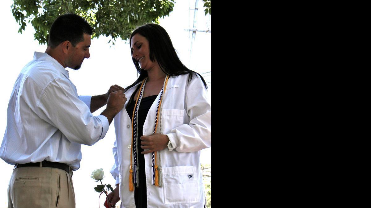 
Melissa Pereira recieves her nursing pin from brother Keith Pereira after completing an Accelerated Second Bachelor of Science in Nursing degree at California State University, Stanislaus Stockton Center in Stockton, Calif., on Saturday, May 2, 2015.
