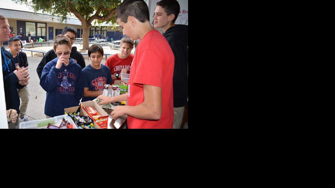 
Christian Alameda, foreground in red, and Gavin Lowell work at Modesto Christian Middle School’s Crusader Hut on Wednesday as fellow students, from center to right, Ben Laffon, Ramsin Essa and Casey Chicoime shop at the snack stand.
