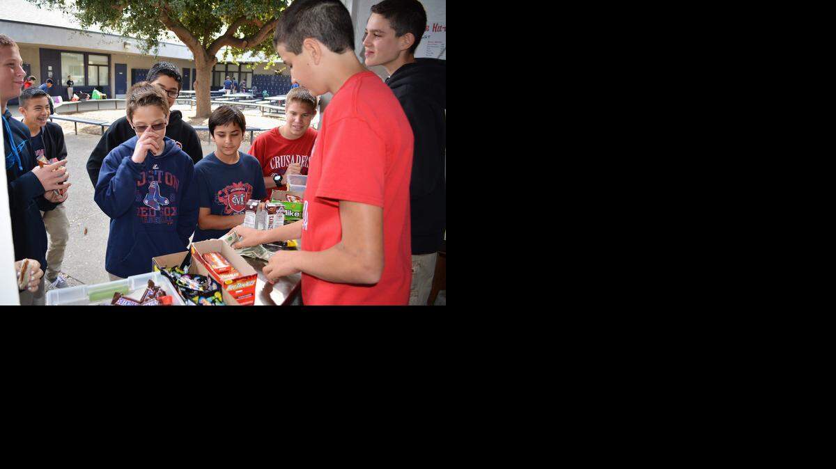 
Christian Alameda, foreground in red, and Gavin Lowell work at Modesto Christian Middle School’s Crusader Hut on Wednesday as fellow students, from center to right, Ben Laffon, Ramsin Essa and Casey Chicoime shop at the snack stand.
