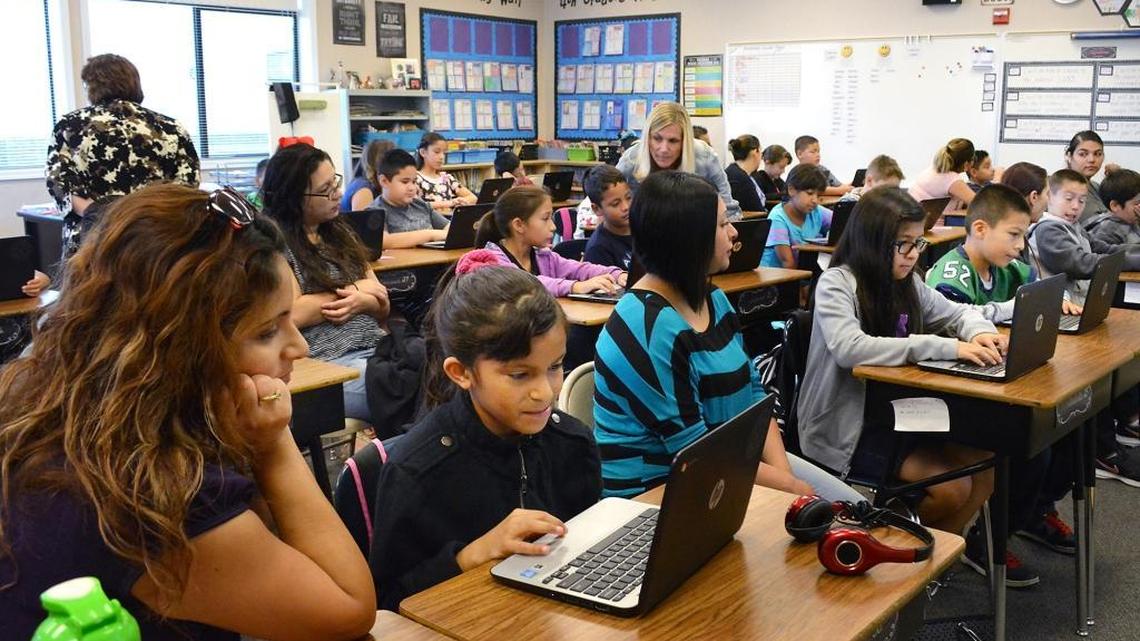 
Blanca Salcido, left, reads as daughter Alyssa, 9, writes a paragraph in the fourth-grade class of JoDee Bonales, center, during Bring Your Parents to School Day at Sinclear Elementary in Ceres on Wednesday.
