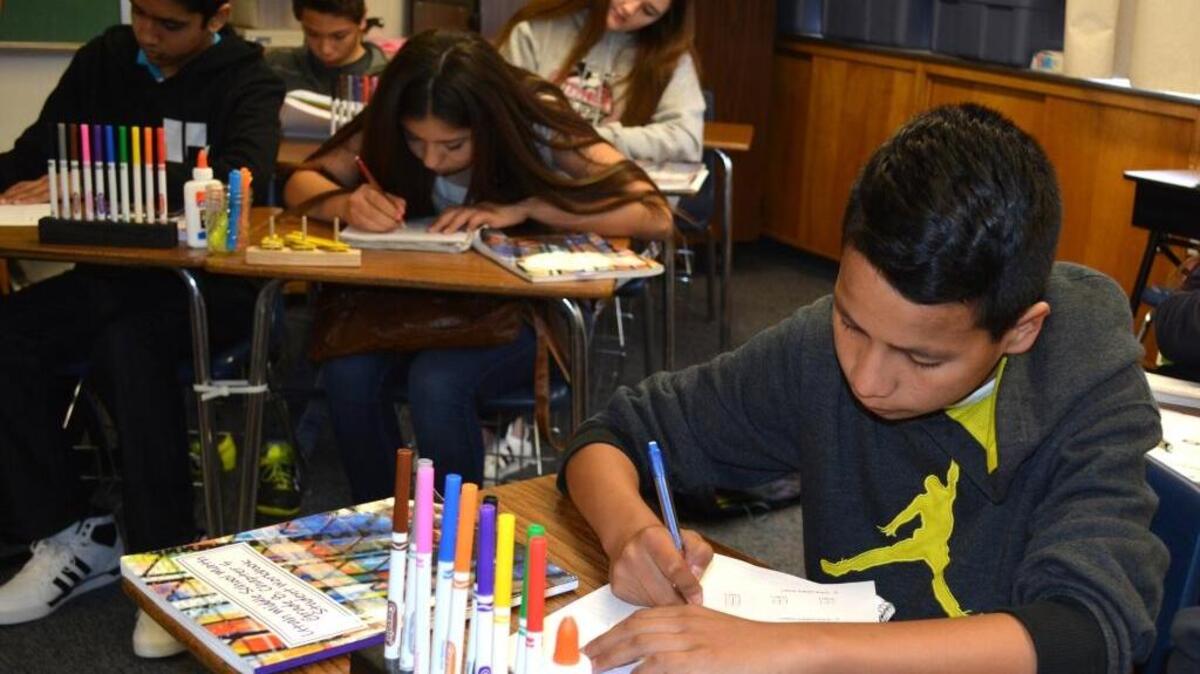 Oscar Gallegos, text at his elbow, does a workbook exercise in Theresa Foote’s eighth-grade class at Roosevelt Junior High in Modesto on March 11, 2016.