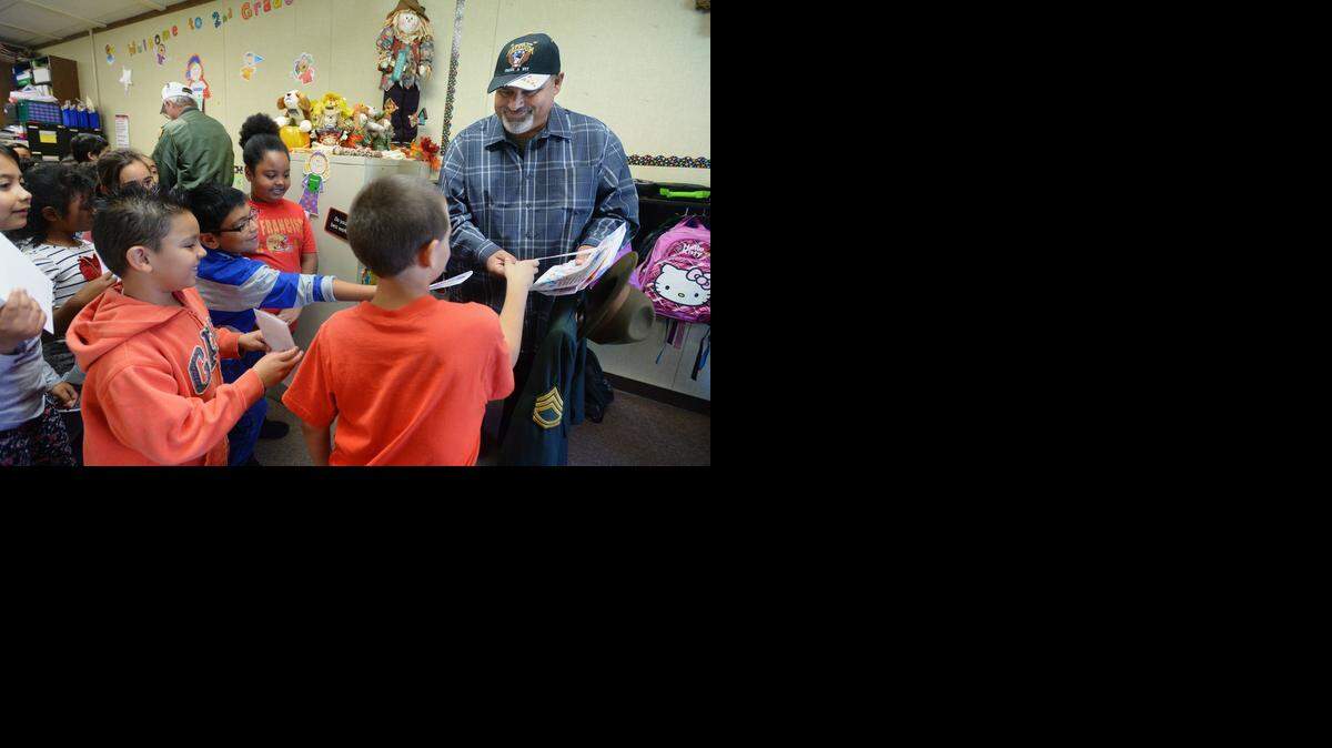 
Second-grade students in Sheila Marable’s class give thank you cards to Army veteran Robert Castillo from Ceres, who attended the assemblies and visited their classroom.
