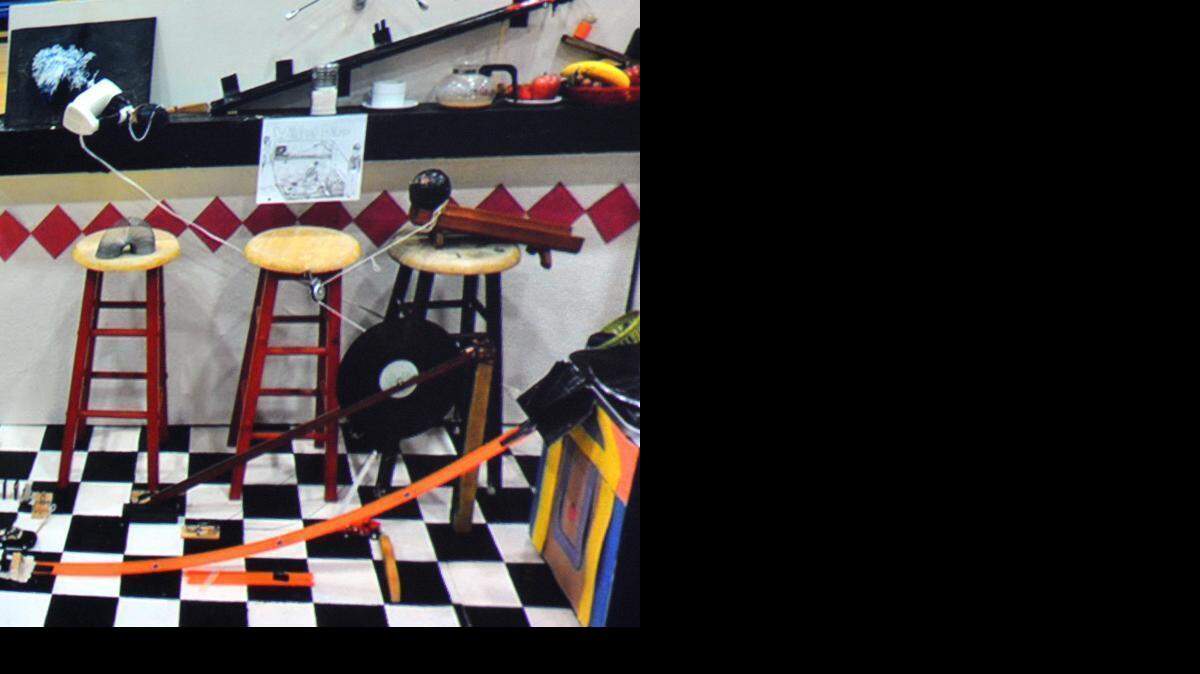 
The winning Waterford High Rube Goldberg machine uses vinyl records, toy classic cars, pulleys, dominoes, a spoon and finally a powered hand mixer, top left, to perform the simple task of erasing a blackboard in 25 steps. The 6-by-4-foot machine will be taken to Wisconsin for the national finals in April. 
