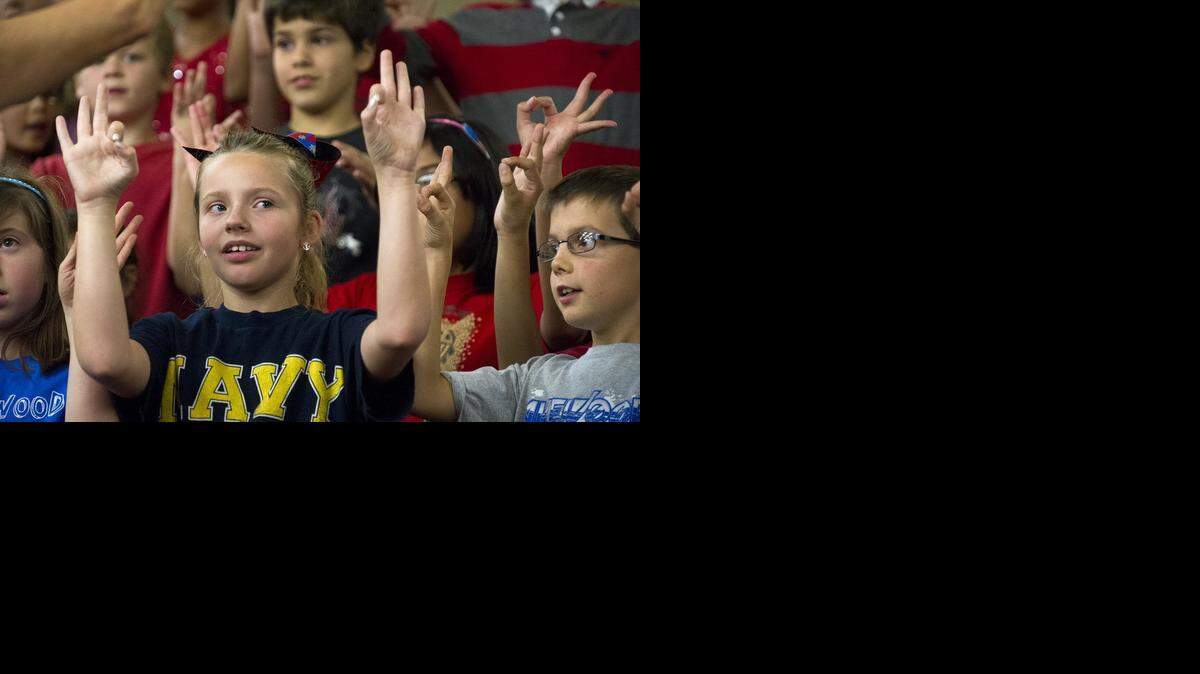 
Third-graders Autumn Altus, left, and Hudson Monday, right, use sign language as the student body sings the national anthem during a tribute to veterans at Lakewood Elementary School in Modesto on Friday. The veterans were family and friends of students and teachers.
